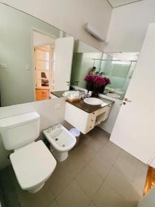 La salle de bains blanche est pourvue de toilettes et d'un lavabo. dans l'établissement Depto de lujo frente al Botánico, à Buenos Aires