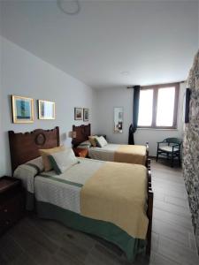 a hotel room with two beds and a window at Casa de Chica Ecoturismo in Lousame