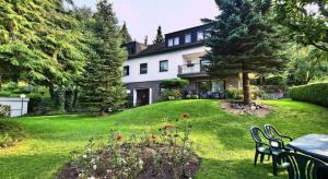 una casa con mesa y sillas en un patio en Ferienwohnungen Casa Ri(e)sig, en Leiwen