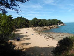 a sandy beach with people on it next to the water at Maison traditionnelle de pêcheur in Île dʼAix +4 photos