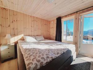 a bedroom with a bed and a large window at Holiday cabin in beautiful surroundings in Vradal