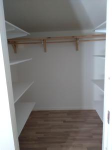 a closet with white shelves and a wooden floor at Sittesta 56 in Ösmo