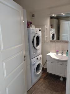 a bathroom with a washing machine and a sink at Sittesta 56 in Ösmo