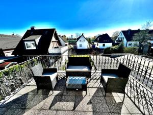 a patio with chairs and a table on a balcony at Praktisches Zimmer im Großen Haus mit garten in Düsseldorf