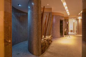 a bathroom with a stone wall and a tile hallway at The Ziba Hotel & Spa in Peschiera del Garda