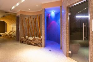 a wellness room with a rock wall and a shower at The Ziba Hotel & Spa in Peschiera del Garda
