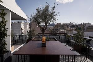 a table on a balcony with a tree on it at The Newel Metaxourgeio in Athens