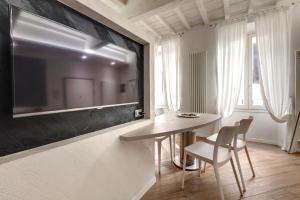 una sala da pranzo con tavolo e TV a parete di Mamo Florence - Rosa Apartment a Firenze
