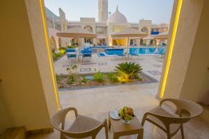 a view of a resort with a pool and tables and chairs at Pickalbatros Jungle Aqua Park - Neverland Hurghada in Hurghada