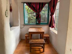 een tafel en banken in een kamer met een raam bij La casa de Tania in San Marcos Sierras