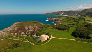 una vista aérea de un campo de golf junto al océano en La Cueva de Villahormes, en Villahormes