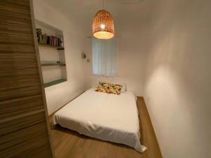 een kleine slaapkamer met een bed en een hanglamp bij La casa de Tania in San Marcos Sierras