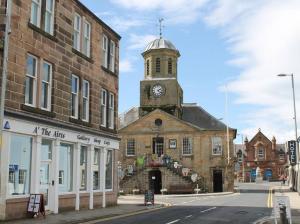 an old building with a clock tower on top of it at Nithsdale Hotel in Sanquhar