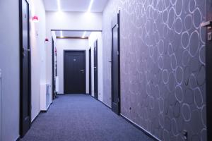 a corridor of a hallway with black doors and purple walls at Apartamenty Maria in Żywiec