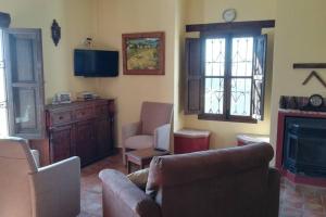 un soggiorno con divano e camino di Castle Tower ground floor apartment in rural holiday park 'Cezanne' a Tolox