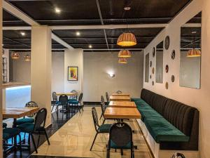 a restaurant with tables and chairs in a room at Exodus Apartments in Bujumbura