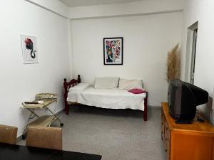 sala de estar con cama y TV en Apart Hotel Comfort City en Salta