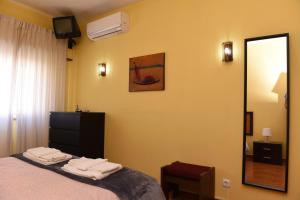 een slaapkamer met een bed met een spiegel en een dressoir bij TMP Apartamento in Quarteira