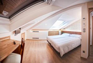 1 dormitorio con 1 cama grande y tragaluz en Pensión O Códice en Santiago de Compostela