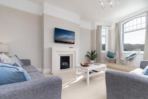 a living room with a couch and a fireplace at Swn y Mor Deganwy in Deganwy