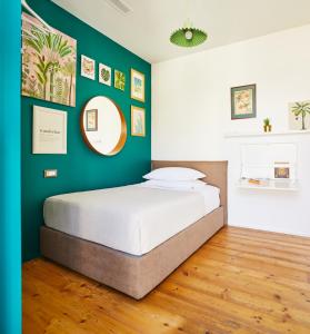 ミラノにあるTropical Micro Studio with Terrace and Duomo Viewsの緑の壁、ベッド付きのベッドルーム1室