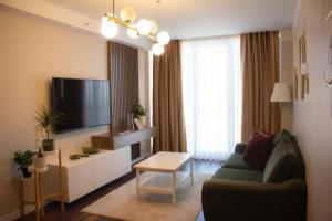 Arenya Home في إسطنبول: غرفة معيشة مع أريكة وتلفزيون بشاشة مسطحة