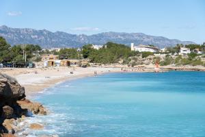 a beach with a bunch of people on it at Hauzify I Casa l'Estany in L'Ametlla de Mar