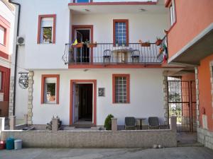 une maison avec un balcon, une table et des chaises dans l'établissement Apartment&Rooms "Globus" Mostar, à Mostar
