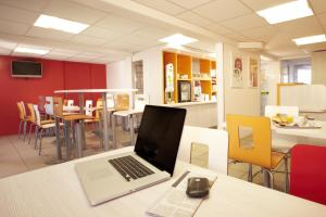 a laptop computer sitting on a table in a restaurant at Premiere Classe Saumur in Saumur