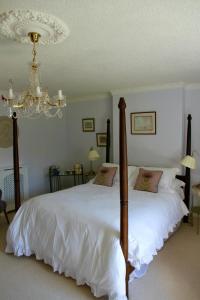 a bedroom with two beds and a chandelier at Thistleyhaugh farmhouse in Longhorsley