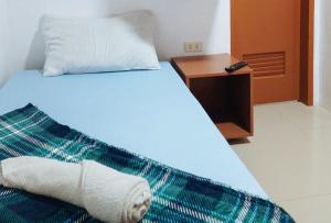um quarto com uma cama com uma almofada e uma mesa de cabeceira em Casa Don Atilano Pension House em Zamboanga