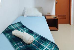 a bedroom with a bed with a towel on it at Casa Don Atilano Pension House in Zamboanga