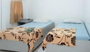 two beds in a small room withermottermott at Casa Don Atilano Pension House in Zamboanga