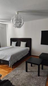 a bedroom with a bed and a chandelier at Very Nice Apartment 15 minutes from Stockholm in Trångsund