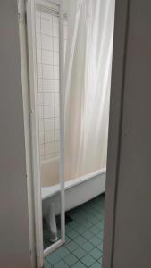 a bathroom with a tub and a shower curtain at Very Nice Apartment 15 minutes from Stockholm in Trångsund