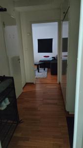a hallway with a living room with a television and a table at Very Nice Apartment 15 minutes from Stockholm in Trångsund