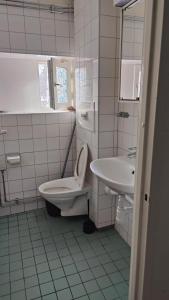 a white bathroom with a toilet and a sink at Very Nice Apartment 15 minutes from Stockholm in Trångsund