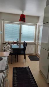 una cocina con mesa y una habitación con ventanas en Very Nice Apartment 15 minutes from Stockholm, en Trångsund