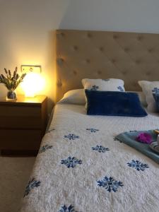 een slaapkamer met een bed met een blauwe en witte sprei bij CAROLA l, "apartamento de lujo a 100m playa Catia" in Ribeira