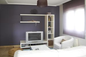 a living room with a white couch and a tv at CAROLA l, "apartamento de lujo a 100m playa Catia" in Ribeira