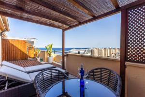 a balcony with a table and chairs and a view of the ocean at Ático Deluxe Mónaco 139 in Santa Cruz de Tenerife
