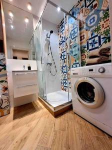 a bathroom with a washing machine and a shower at Apartament Szeroka Gdańsk, Stare Miasto in Gdańsk