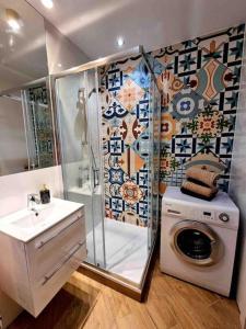 a bathroom with a shower and a washing machine at Apartament Szeroka Gdańsk, Stare Miasto in Gdańsk