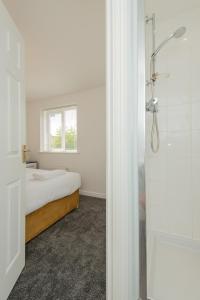 a bedroom with a bed and a window and a shower at Thinford View in Spennymoor