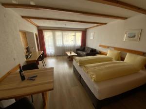 ein Wohnzimmer mit 2 Betten und einem Sofa in der Unterkunft Alfa Appartements Superior in Leukerbad