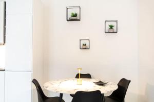 uma sala de jantar branca com uma mesa e cadeiras em Corso Cavour - Raffinatezza nel cuore cittadino em Pavia