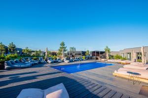 a large swimming pool with lounge chairs and a resort at Jūros banga in Palanga