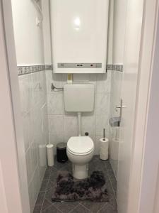a bathroom with a toilet with a tv above it at Modern Havanna Appartment in Graz