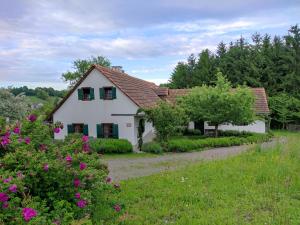una casa blanca con techo rojo y algunas flores en Lamplberg en Graben