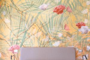 pared con papel pintado floral y ordenador portátil en Lilium Maris Hotel, en Bibione